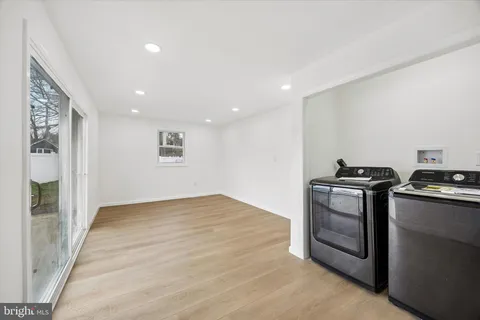 a view of empty room with wooden floor and stainless steel appliances