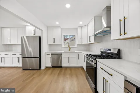 a kitchen with a refrigerator a stove top oven a sink and cabinets