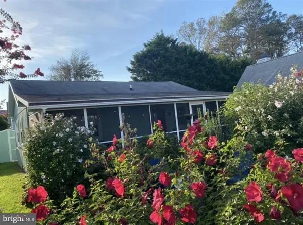 a view of a house that has a lot of flower plants