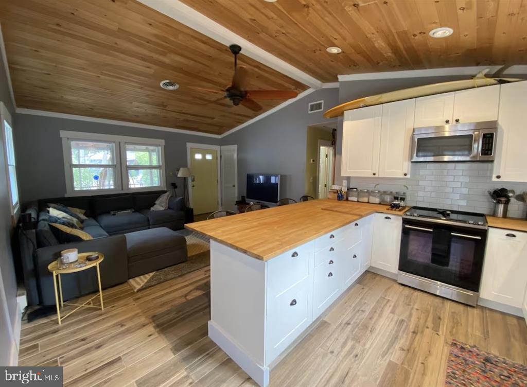 13803 Fountain Road Ocean City, MD 21842 - Photo 18 of 23 a large kitchen with stainless steel appliances granite countertop a stove and a wooden floors
