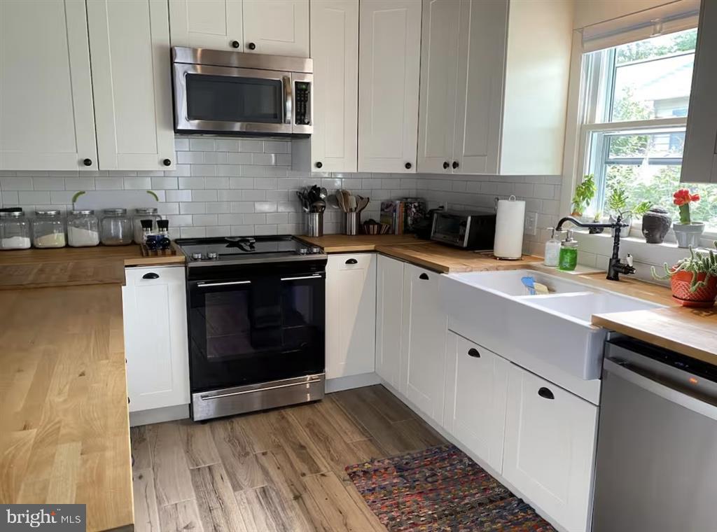 13803 Fountain Road Ocean City, MD 21842 - Photo 8 of 23 a kitchen with stainless steel appliances granite countertop a stove a sink and a microwave