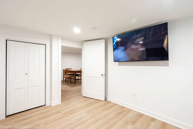 a view of a livingroom with wooden floor and a ceiling fan