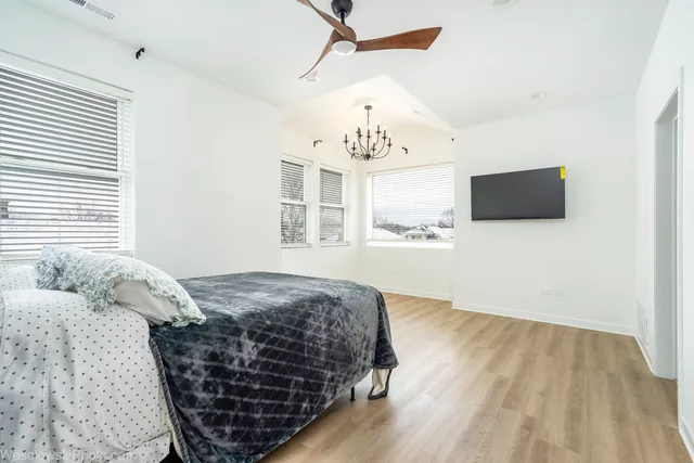 a bedroom with a bed and a flat tv screen on the dresser