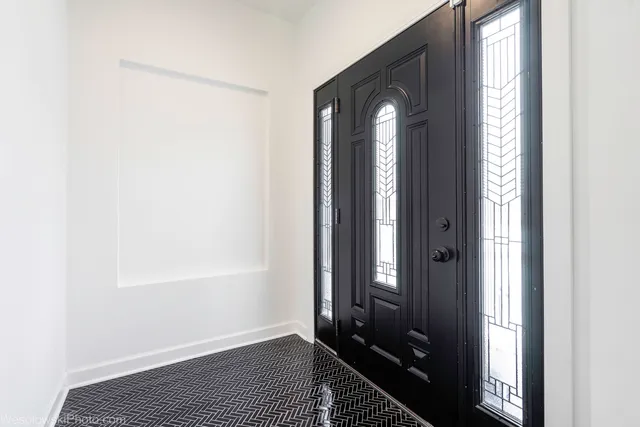 a view of a hallway with wooden floor and a bathroom