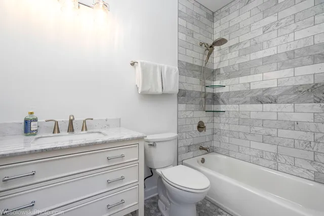 a bathroom with a granite countertop toilet a sink and bathtub