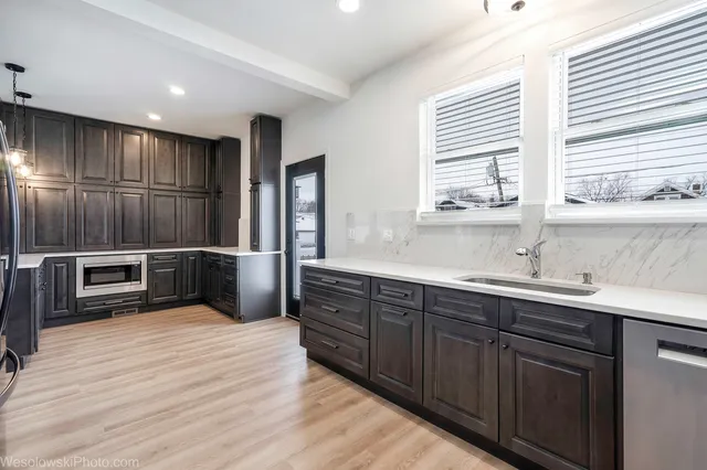a kitchen with stainless steel appliances wooden cabinets a sink and a window