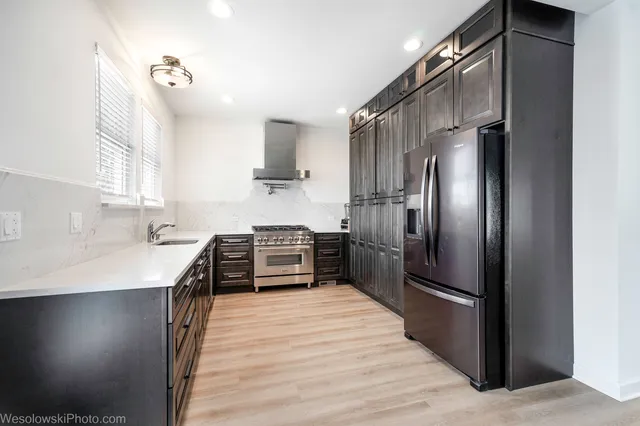 a kitchen with stainless steel appliances a refrigerator and a stove top oven