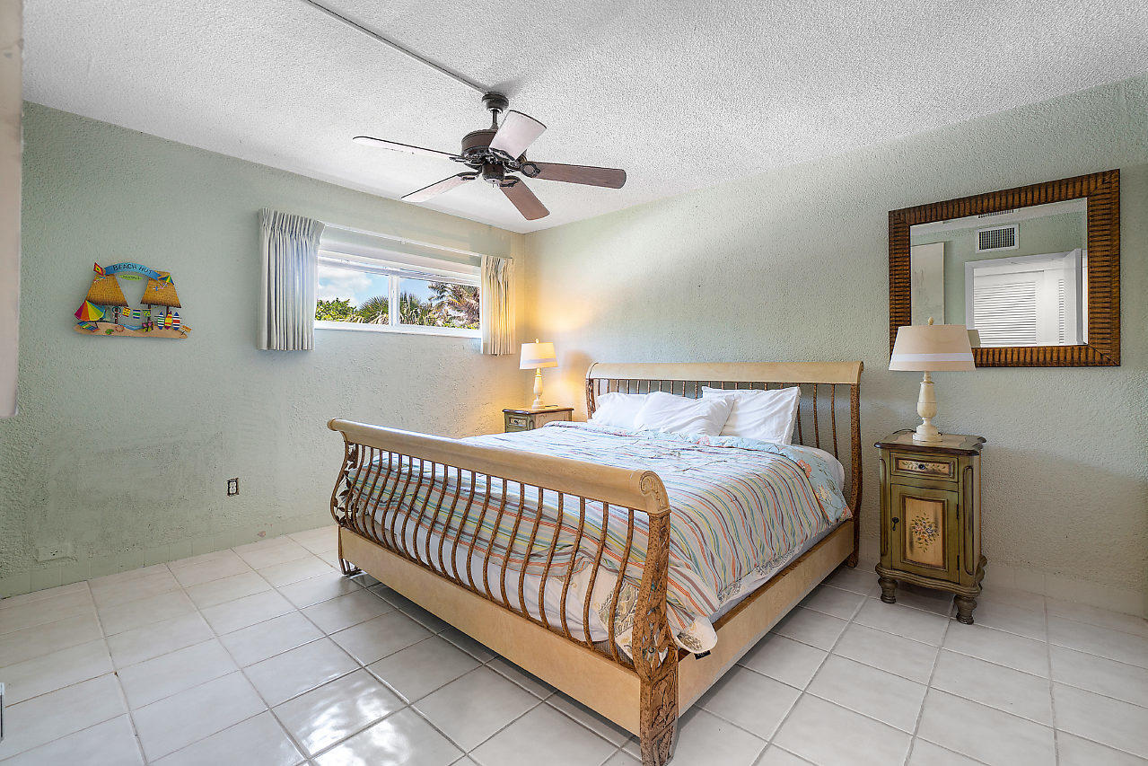 5700 Old Ocean Boulevard, Unit V Ocean Ridge, FL 33435 - Photo 16 of 24 a bedroom with a bed and a chandelier