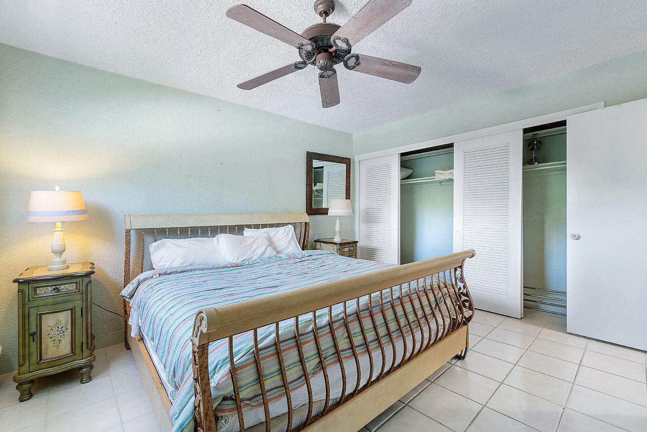 5700 Old Ocean Boulevard, Unit V Ocean Ridge, FL 33435 - Photo 17 of 24 a bedroom with a bed and a chandelier