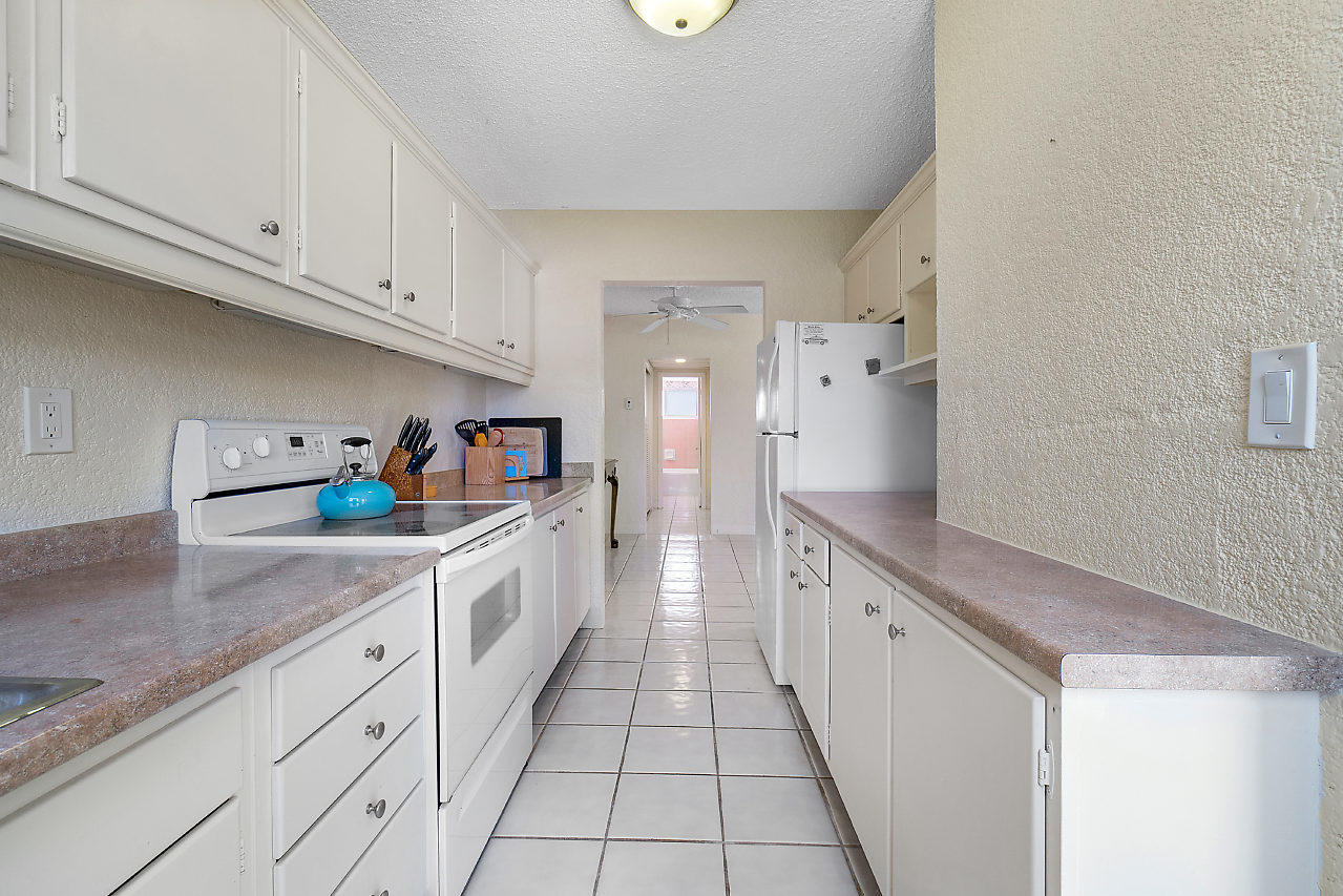 5700 Old Ocean Boulevard, Unit V Ocean Ridge, FL 33435 - Photo 20 of 24 a kitchen with granite countertop a sink and cabinets