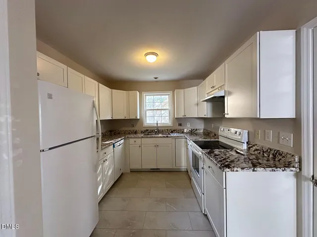 a kitchen with a refrigerator a stove top oven a sink and dishwasher