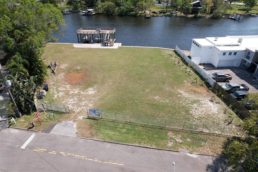 an aerial view of a house with a yard and lake view