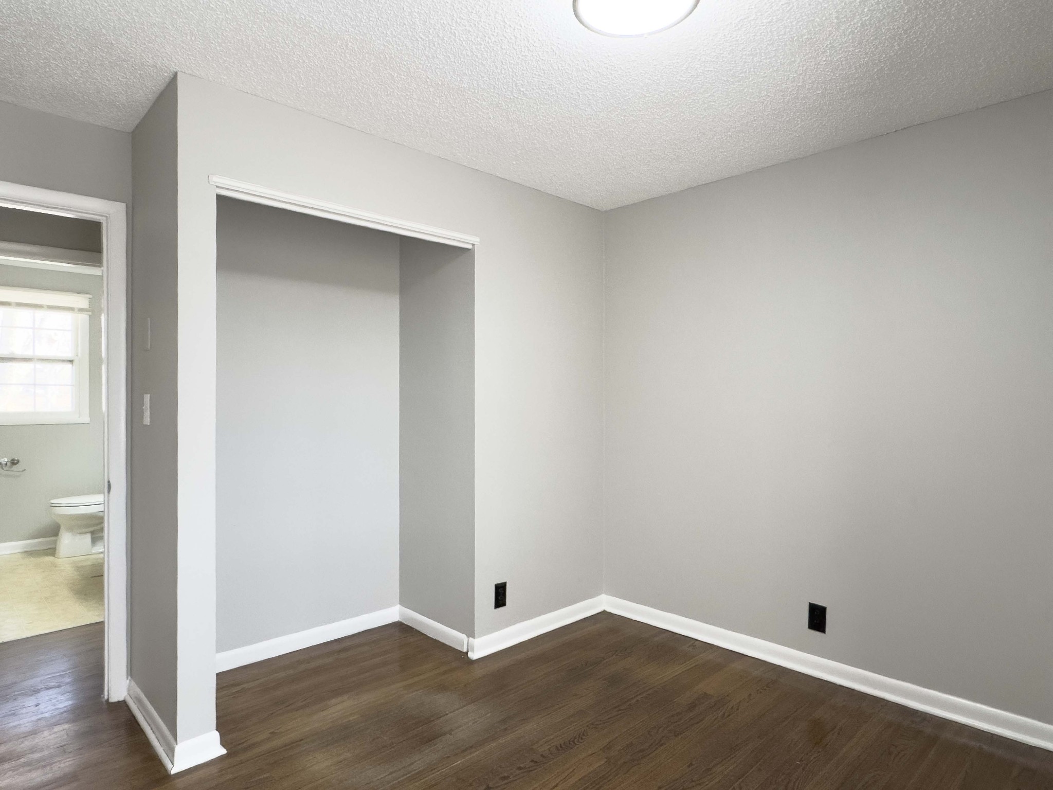 328 Dunbar Cave Road Clarksville, TN 37043 - Photo 16 of 26 an empty room with wooden floor and a toilet