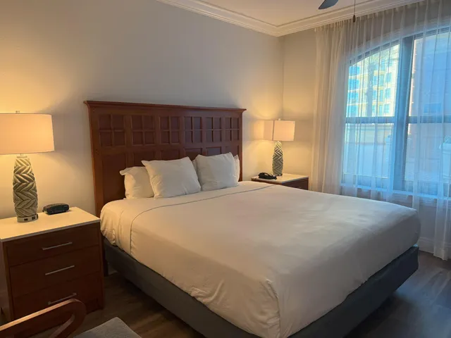 a bedroom with a bed and a lamp on the dresser