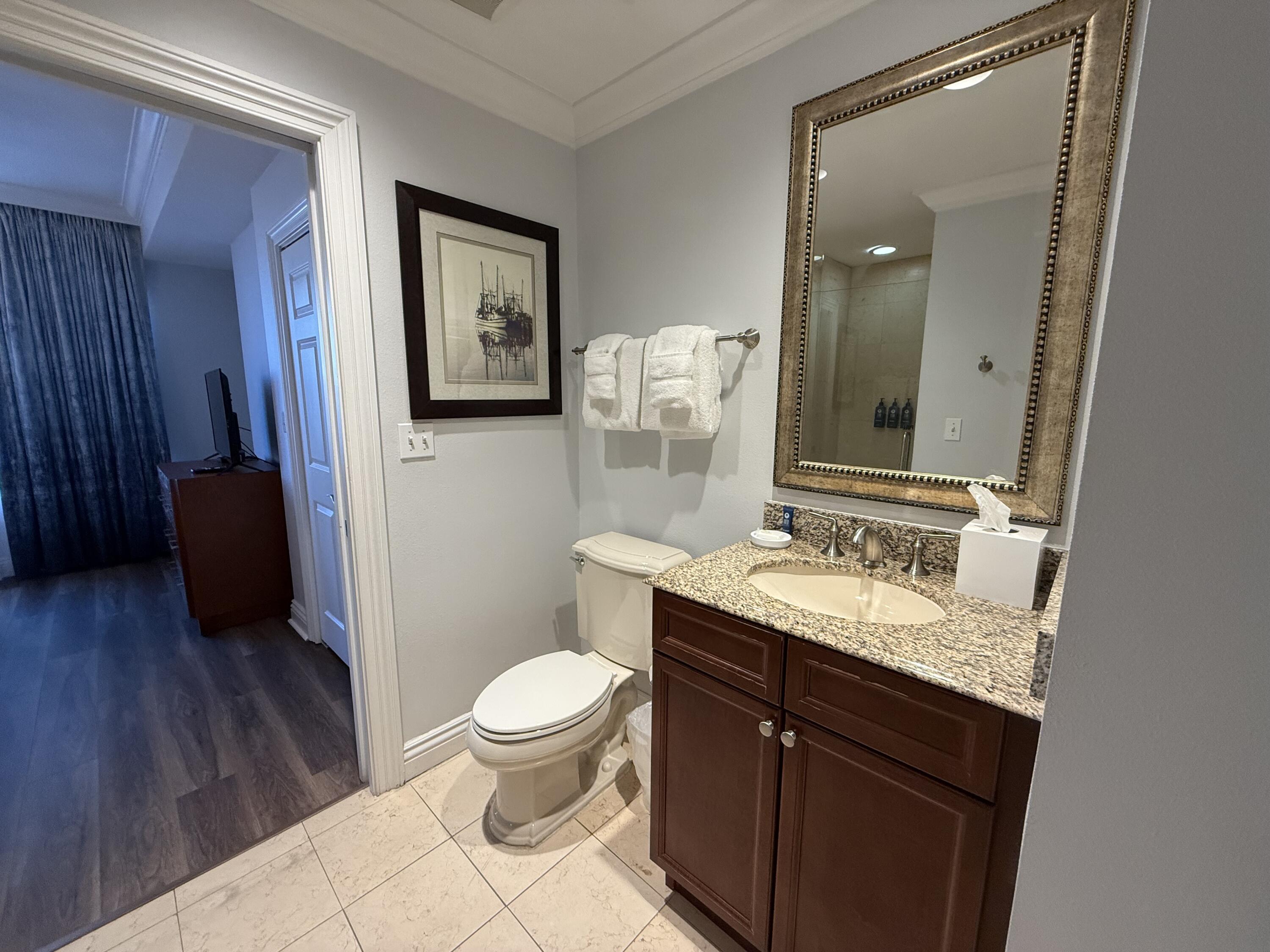 10 Harbor Boulevard, Unit E102F Destin, FL 32541 - Photo 16 of 29 a bathroom with a granite countertop toilet sink and mirror