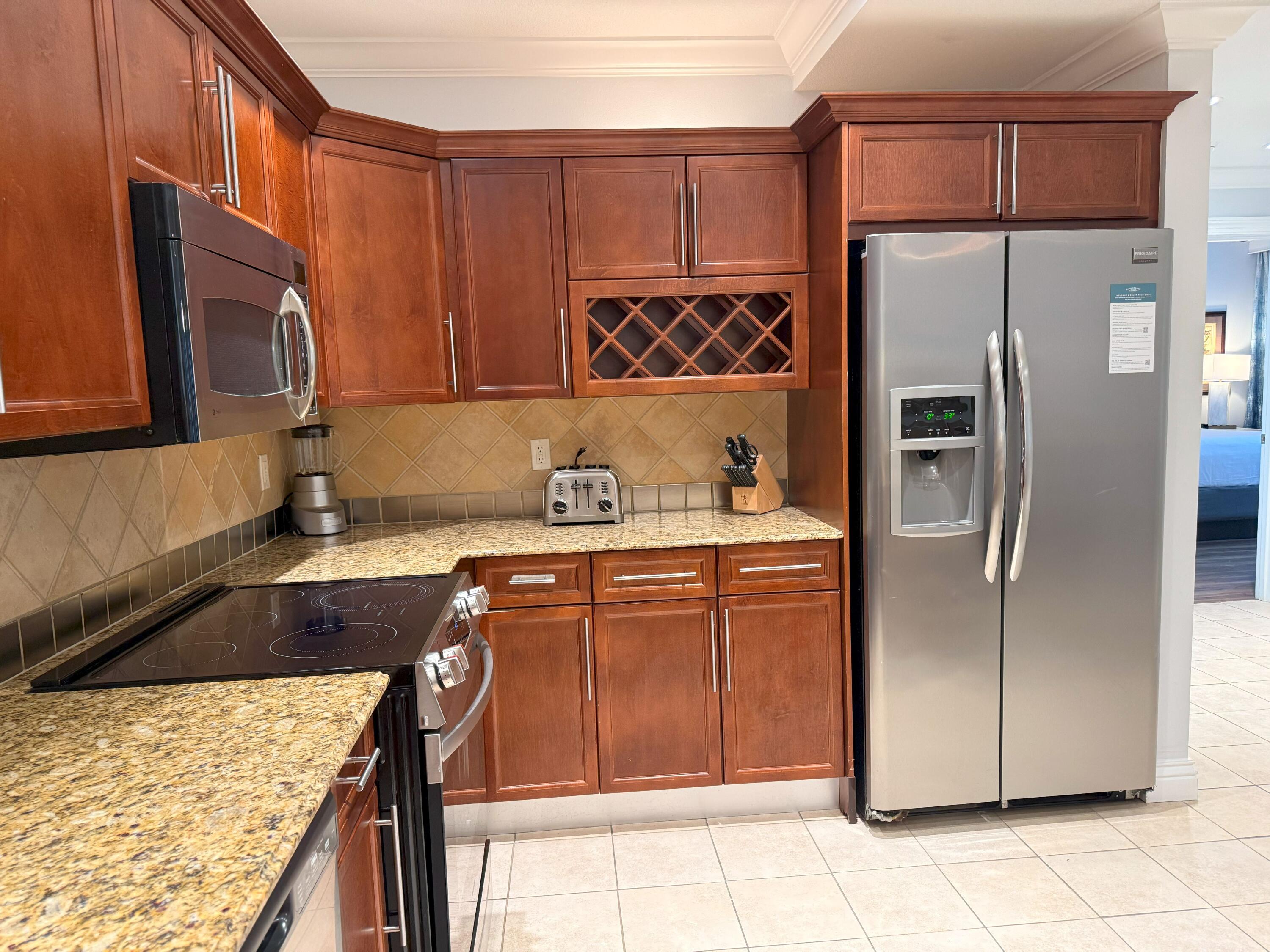 10 Harbor Boulevard, Unit E102F Destin, FL 32541 - Photo 10 of 29 a kitchen with stainless steel appliances granite countertop a refrigerator stove top oven and sink