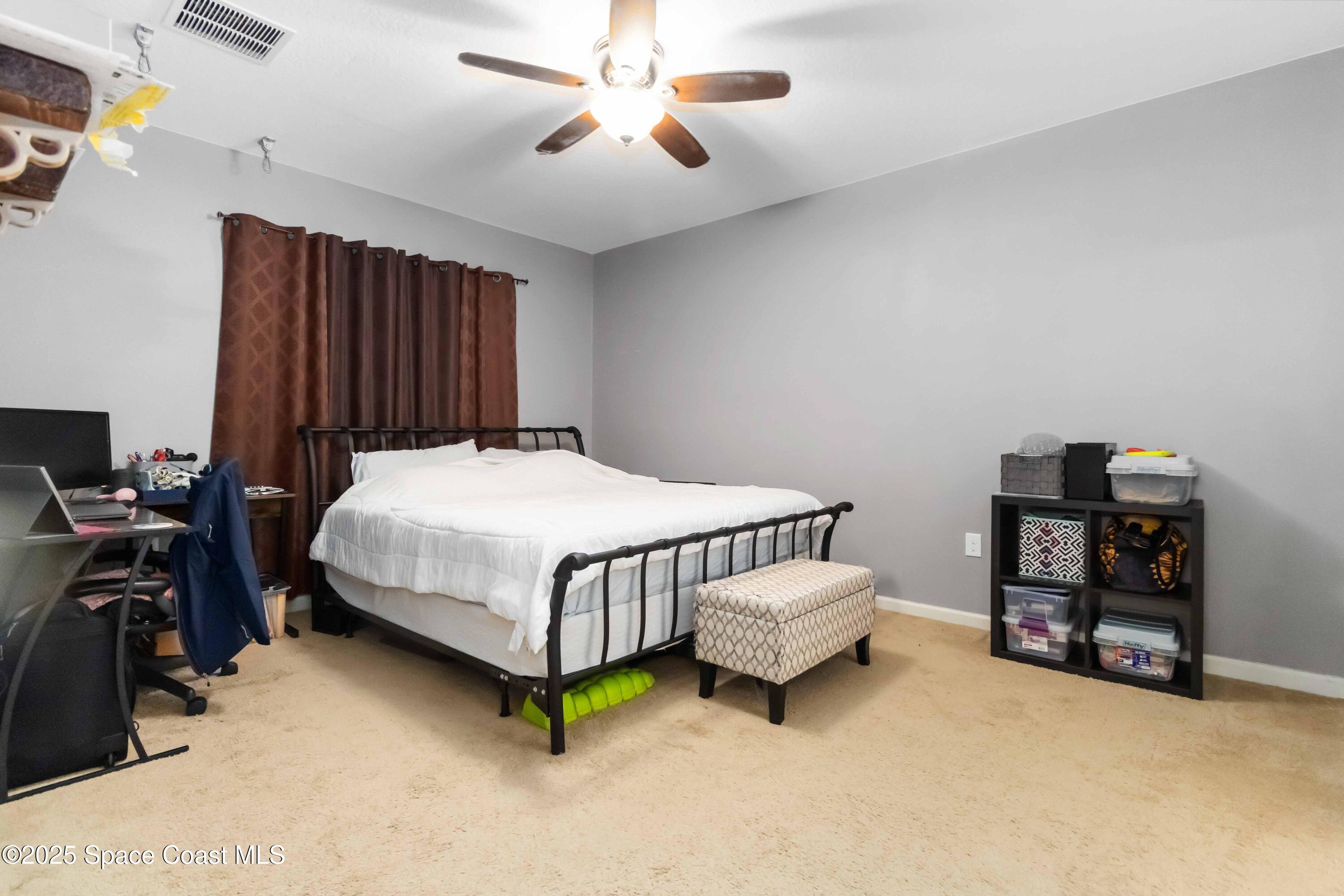 1070 Swiss Pointe Lane Rockledge, FL 32955 - Photo 19 of 29 a bedroom with a bed closet and a chandelier