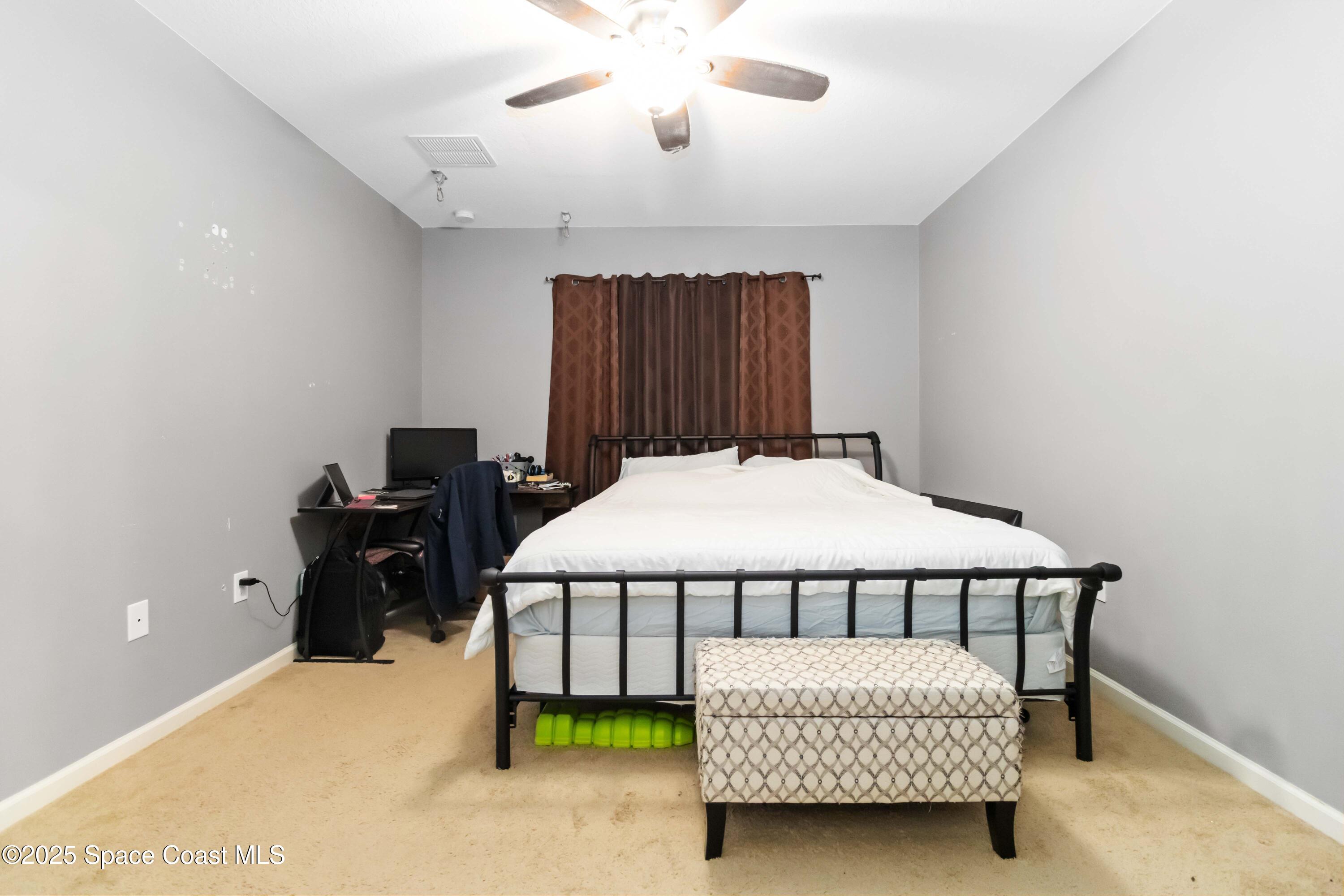 1070 Swiss Pointe Lane Rockledge, FL 32955 - Photo 20 of 29 a bedroom with a bed and a chandelier