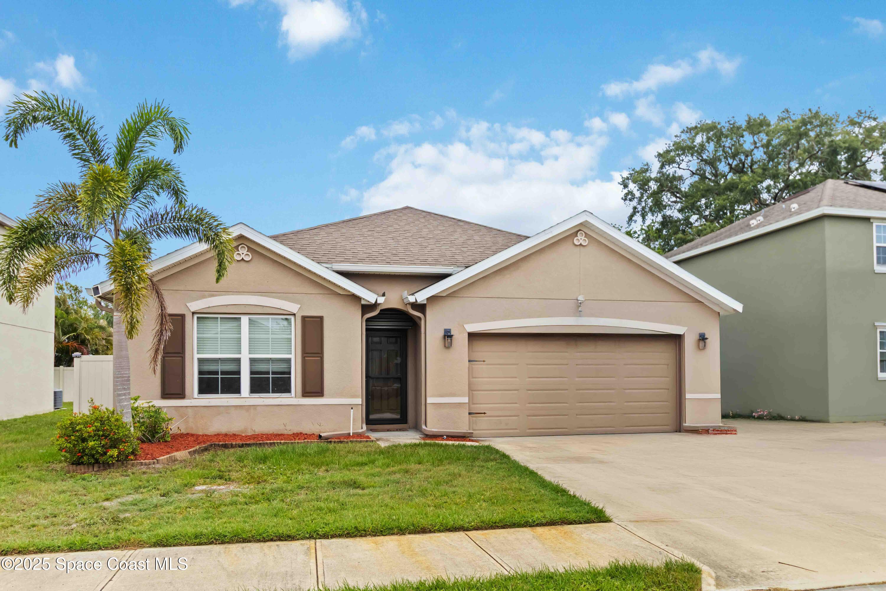 1070 Swiss Pointe Lane Rockledge, FL 32955 - Photo 2 of 29 a front view of a house with a yard and garage