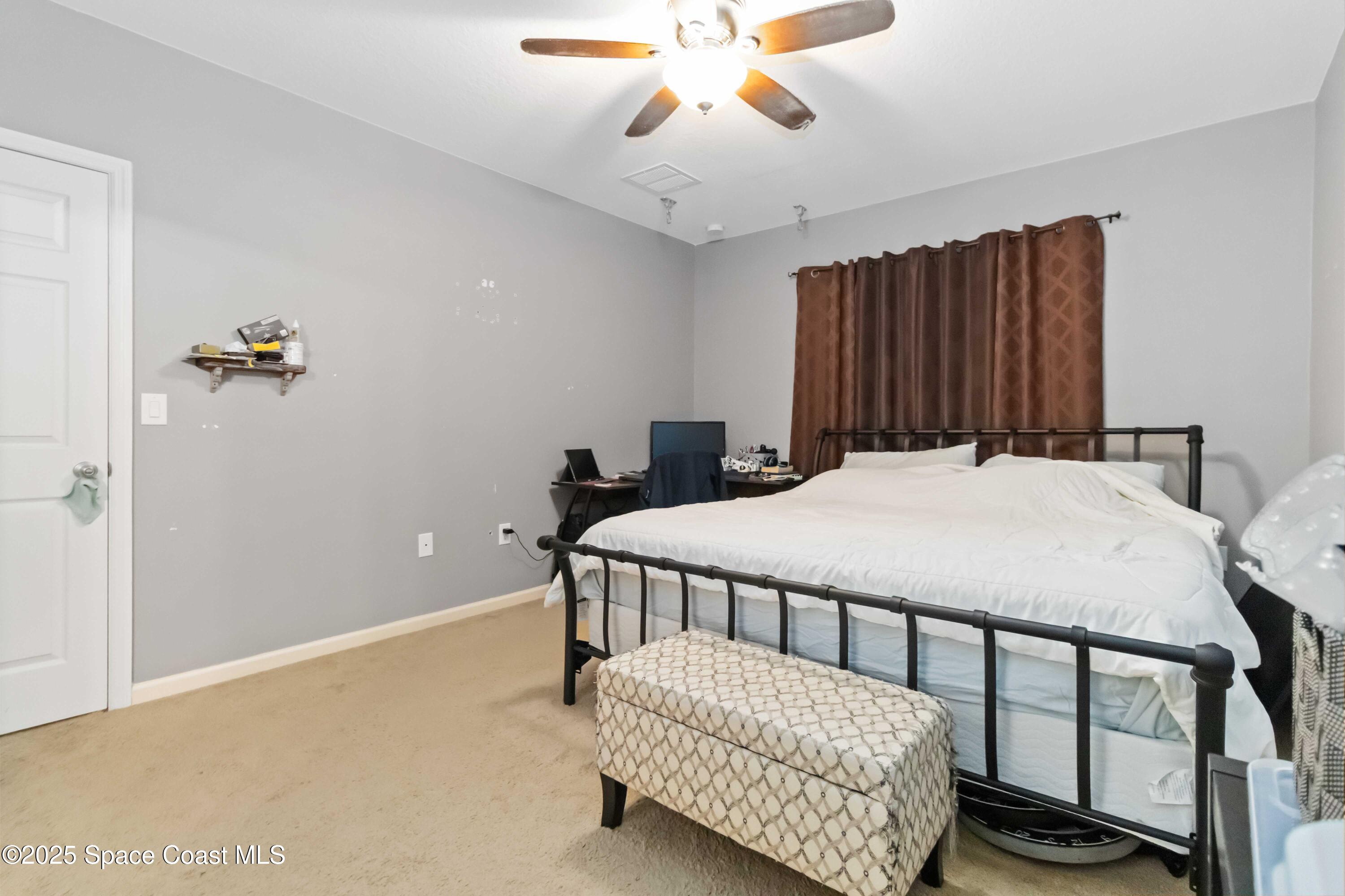 1070 Swiss Pointe Lane Rockledge, FL 32955 - Photo 21 of 29 a bedroom with a bed and a chandelier