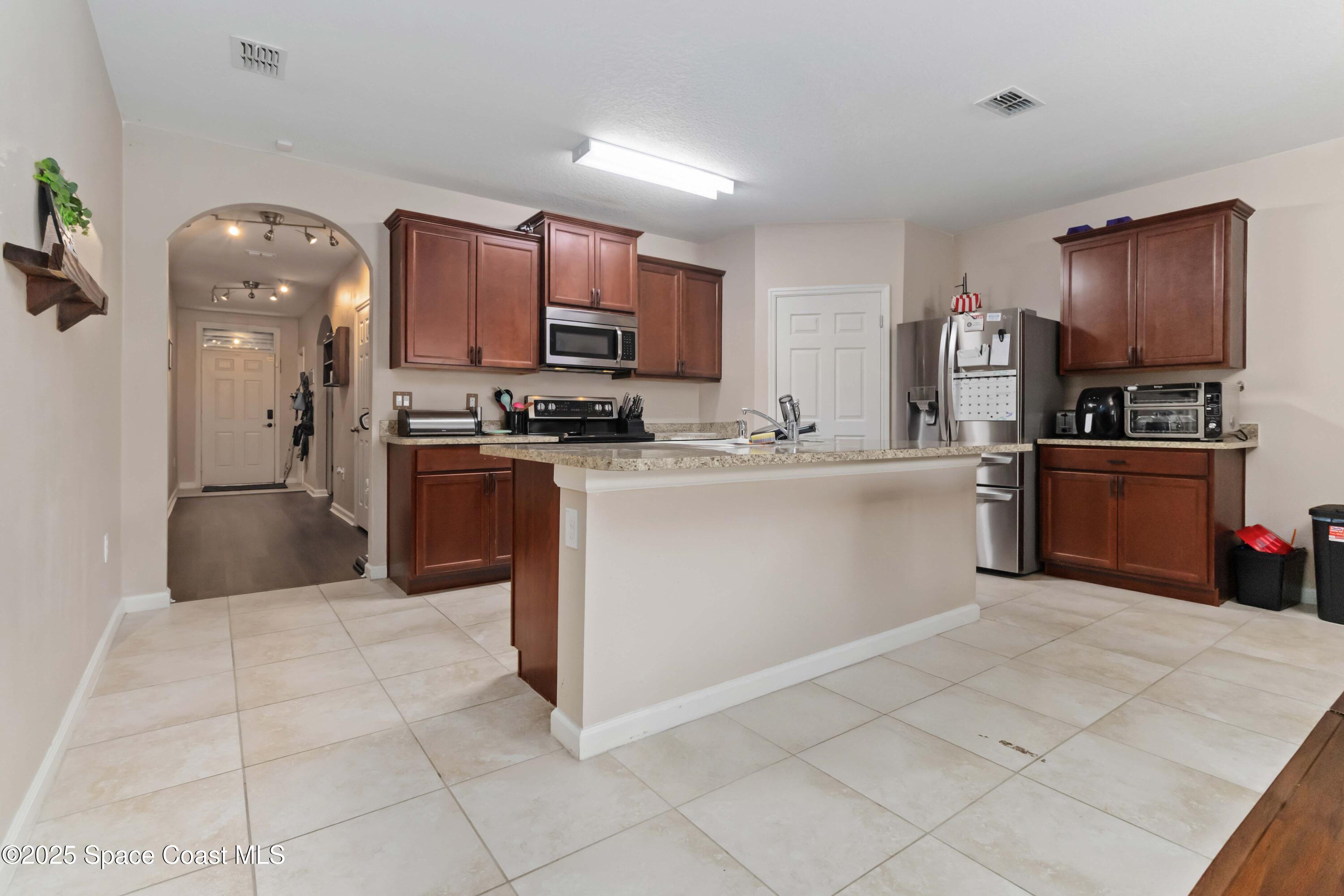 1070 Swiss Pointe Lane Rockledge, FL 32955 - Photo 7 of 29 a kitchen with stainless steel appliances granite countertop a stove top oven a sink a counter top space and cabinets