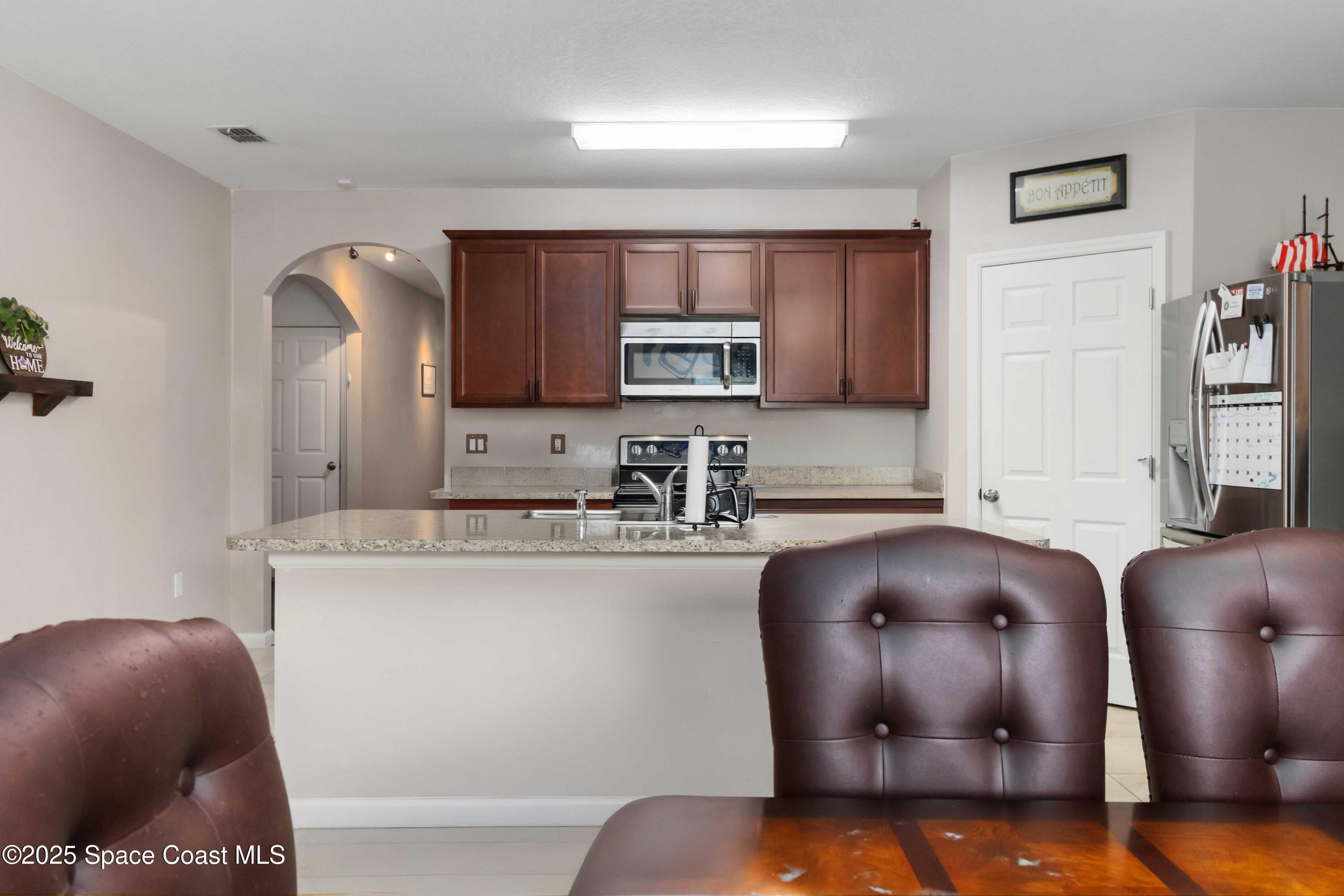 1070 Swiss Pointe Lane Rockledge, FL 32955 - Photo 8 of 29 a kitchen with stainless steel appliances granite countertop a sink a stove top oven a counter space and cabinets