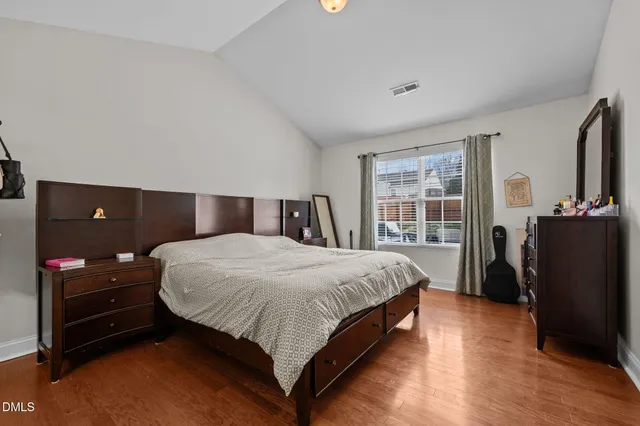 a bedroom with a bed and a flat tv screen on dresser