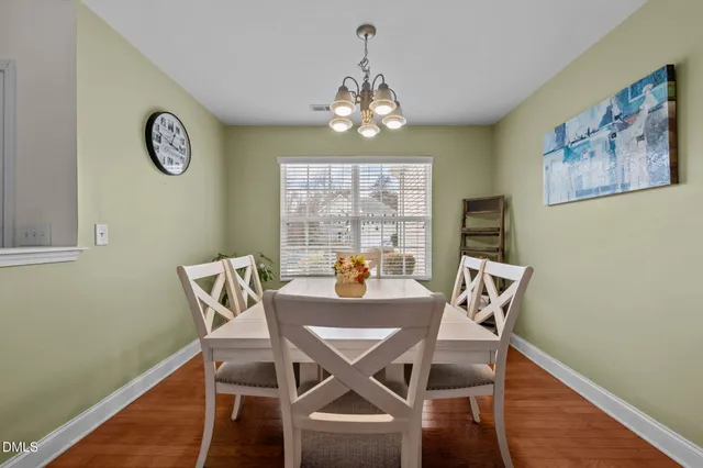 a view of a dining room with furniture a chandelier and wooden floor