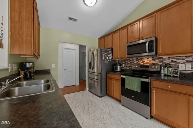a kitchen with stainless steel appliances granite countertop a stove microwave and refrigerator