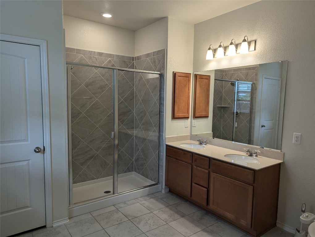 612 Ayinger Lane Austin, TX 78728 - Photo 11 of 13 a bathroom with a double vanity sink mirror and shower