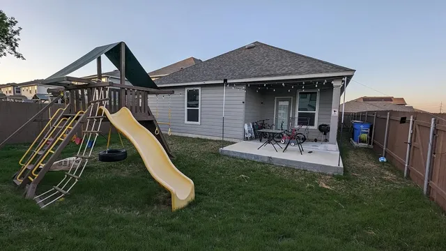 a view of a house with backyard and a slide