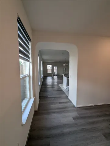 a hallway with wooden floor and stairs