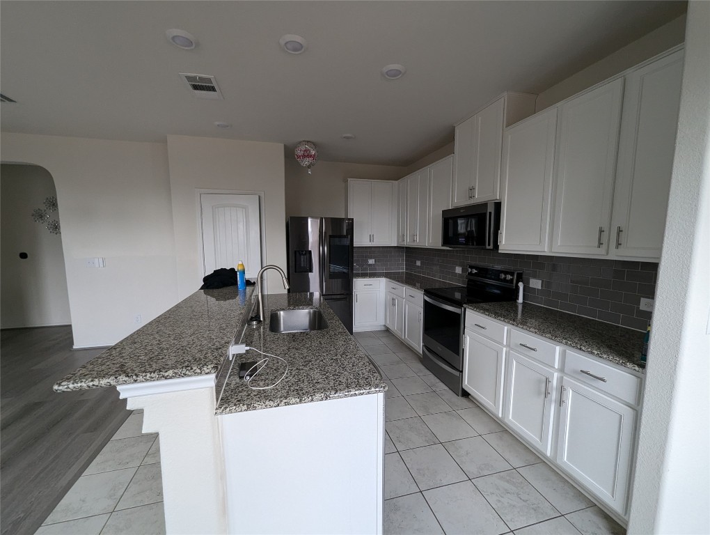 612 Ayinger Lane Austin, TX 78728 - Photo 5 of 13 a kitchen with stainless steel appliances granite countertop a sink stove and refrigerator