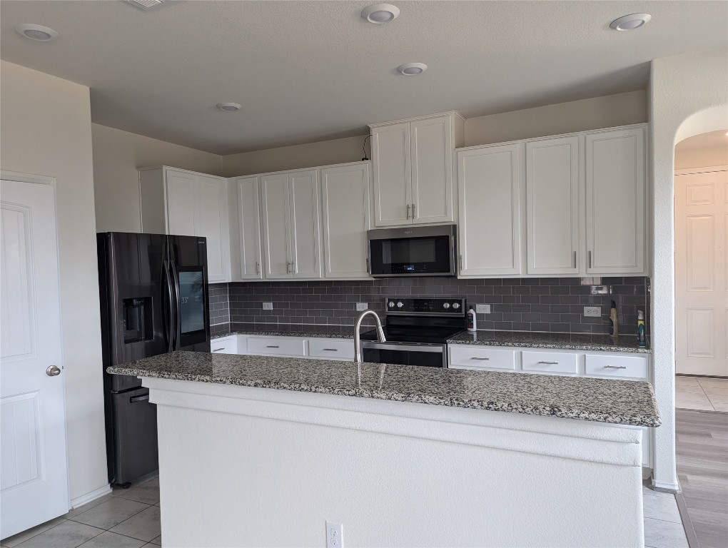 612 Ayinger Lane Austin, TX 78728 - Photo 6 of 13 a kitchen with stainless steel appliances granite countertop a refrigerator a stove a sink and a granite counter tops
