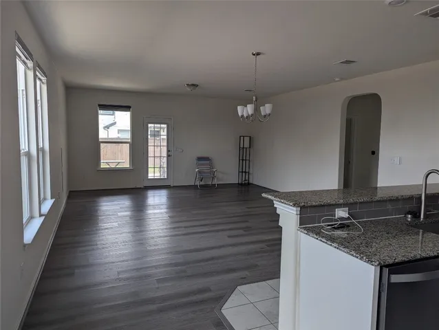 a view of a kitchen with a sink dishwasher a stove and wooden floor