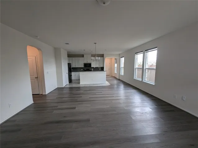 a view of empty room with wooden floor and window