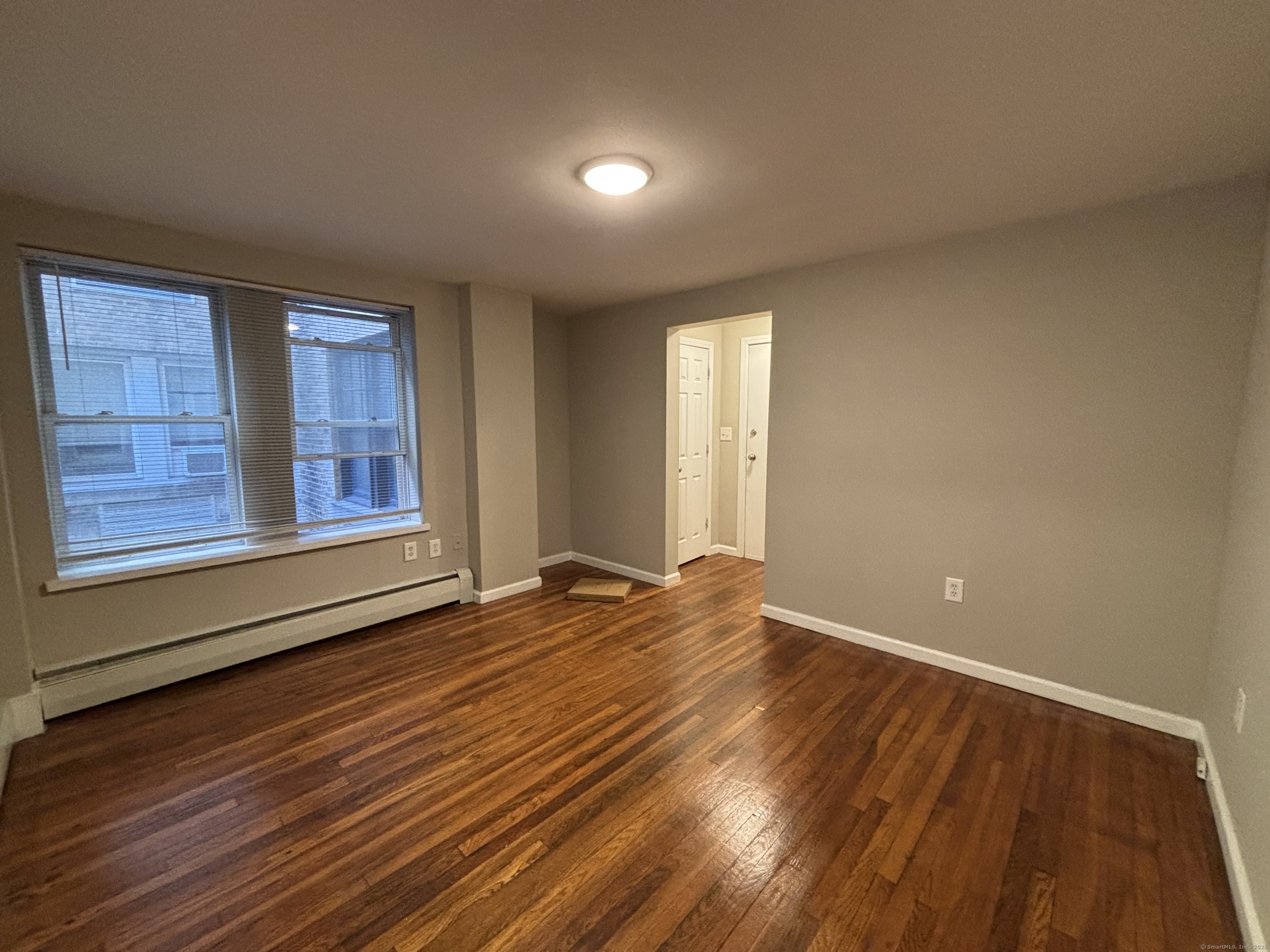 225 Golden Hill Street, Unit 3F Bridgeport, CT 06604 - Photo 6 of 12 a view of an empty room with wooden floor and a window