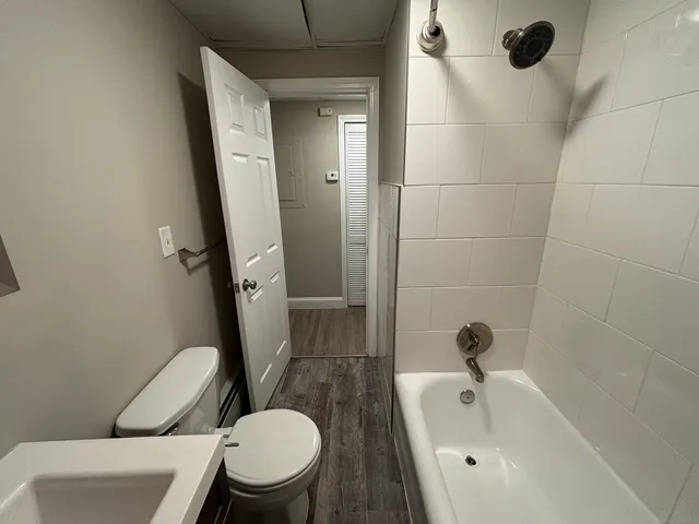 a white toilet sitting next to a bath tub