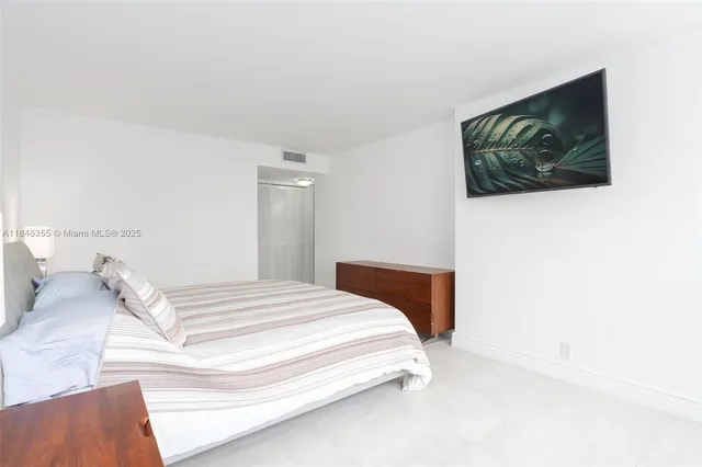 a bedroom with a bed and a painting on the wall