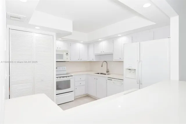 a kitchen with a sink cabinets stainless steel appliances and a window