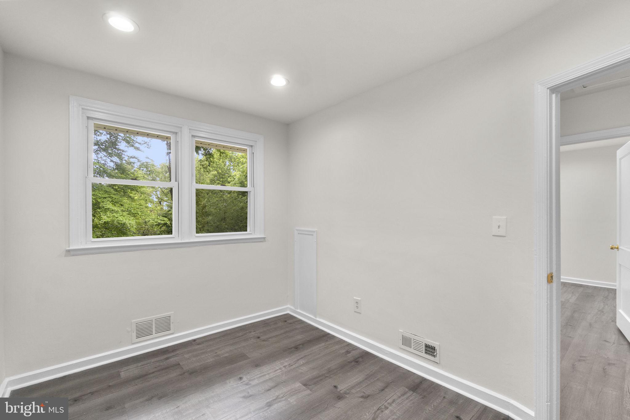 3658 Clifmar Road Baltimore, MD 21244 - Photo 29 of 43 an empty room with wooden floor and windows