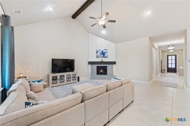 a living room with furniture a flat screen tv and a fireplace
