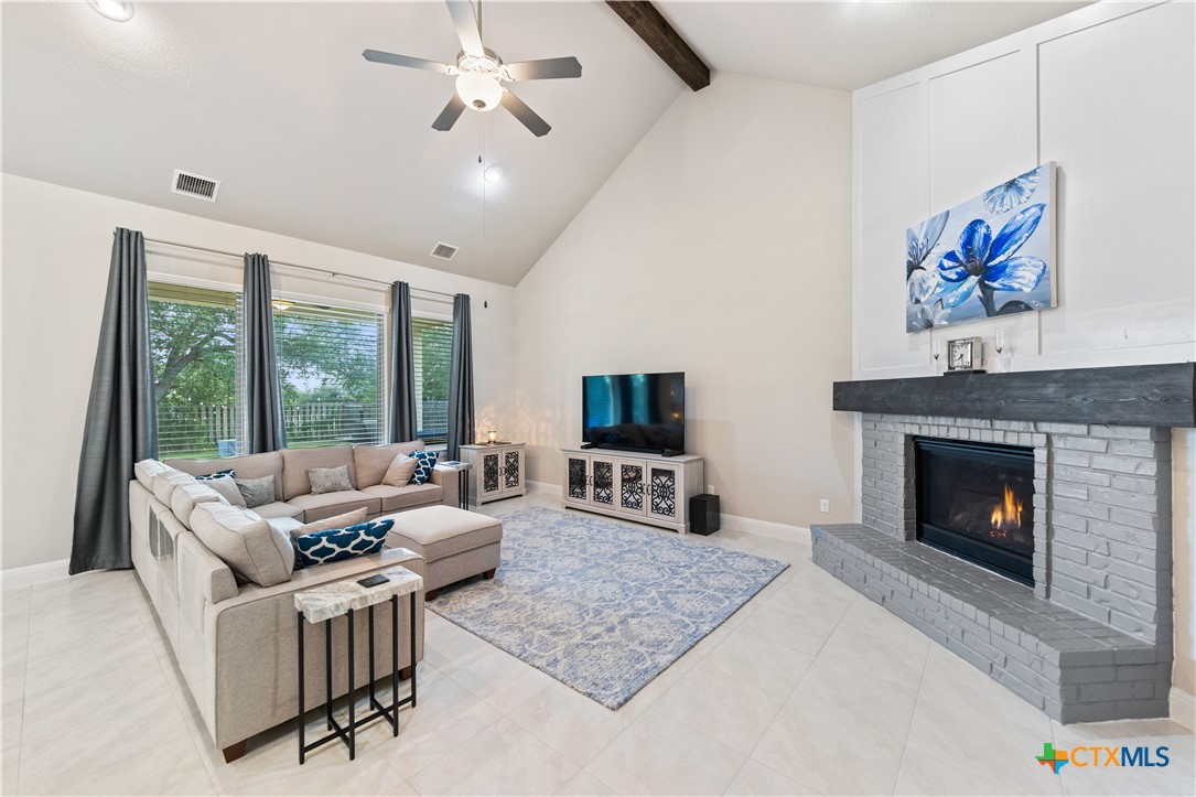 264 Axis Loop Georgetown, TX 78628 - Photo 10 of 33 a living room with furniture a flat screen tv and a fireplace