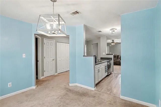 a view of a kitchen with a sink and dishwasher a stove top oven with wooden floor