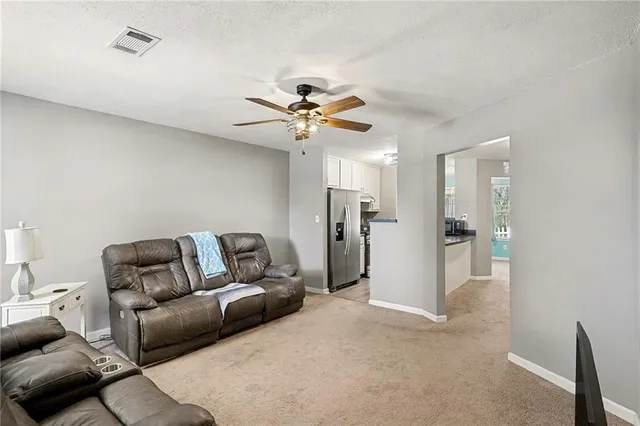 a living room with furniture and a ceiling fan