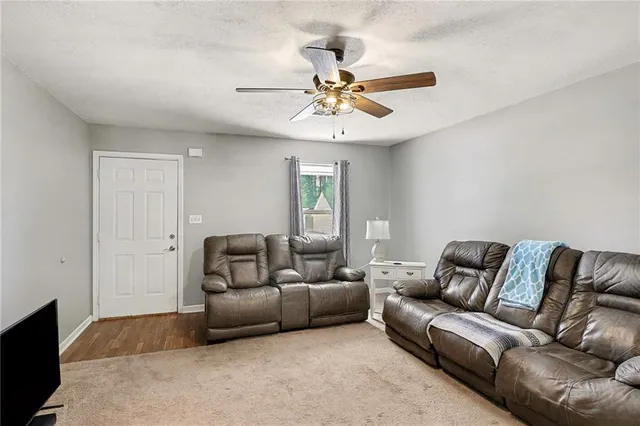 a living room with furniture a ceiling fan and a window