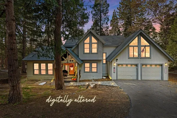 a front view of a house with a tree in front of it