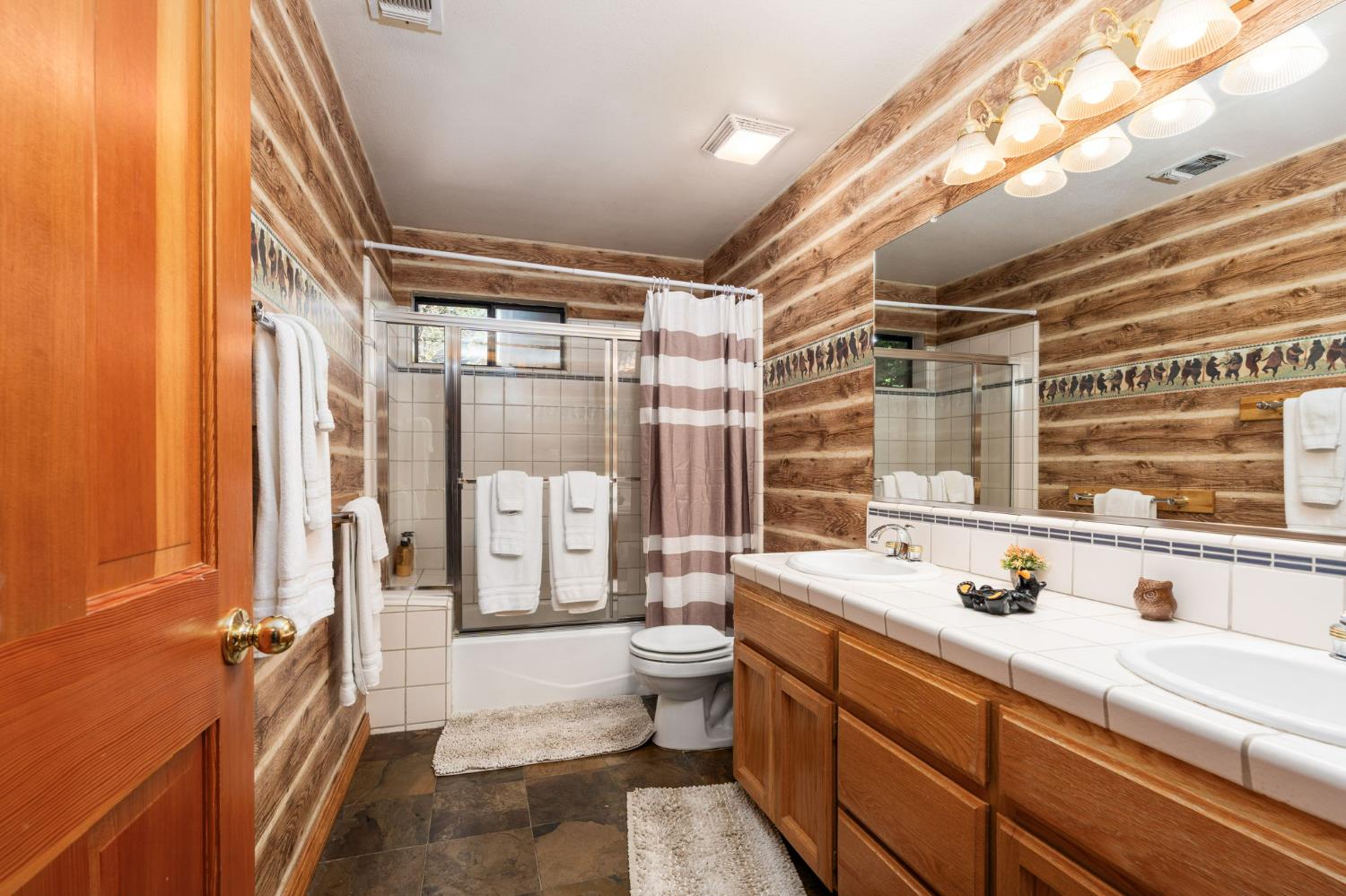 41811 Gray Rock Road Shaver Lake, CA 93664 - Photo 30 of 33 a bathroom with a double vanity sink toilet mirror and tub