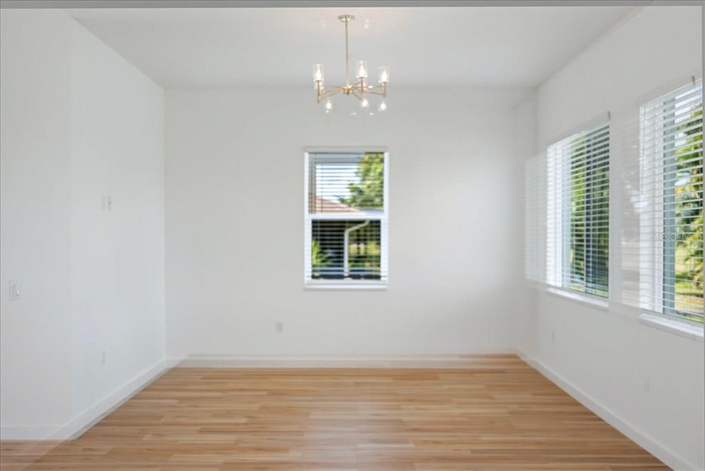 1215 Rio De Janeiro Avenue Punta Gorda, FL 33983 - Photo 23 of 65 a view of an empty room with wooden floor and a window