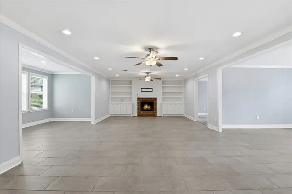 a view of an empty room with a fireplace and a window